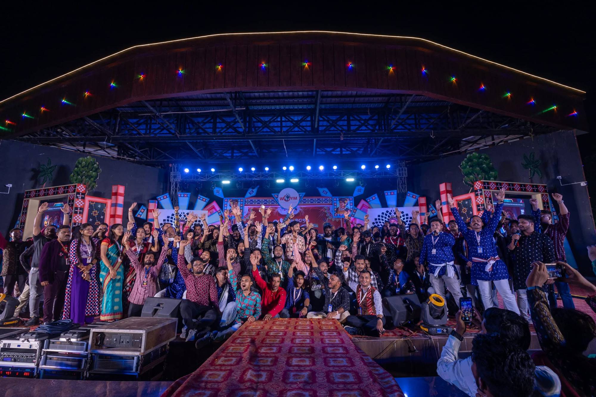 WOYM team and volunteers celebrating together on stage